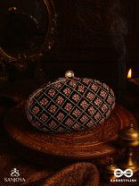 NAZRANA – CURVED MAROON SHADE TEXTILE CLUTCH WITH ORNAMENTED GRID EMBELLISHMENT AND GOLDEN METAL FRAME