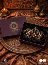 ROHINI – POLISHED BRONZE BROWN TEXTILE CLUTCH WITH FACETED JEWEL ACCENTS AND GOLDEN METAL FRAME