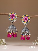 Suryaruchi-Sun's Radiance-Lavish pink earrings enamelled with a sun motif and oxidized jhumka adorned with beads and ghunghroos