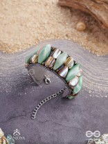 Shuktimālā- Shell band-Expandable bracelet crafted from shell beads, combining turquoise and beige-brown tones with a brassy finish.