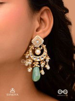 PURNIMA PHOOL – FULL MOON FLOWER AN EXQUISITE KUNDAN EARRING FEATURING GOLDEN DESIGNS, PEARL CLUSTERS, AND A GREEN GEMSTONE DROP, SYMBOLIZING ELEGANCE