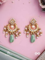 PURNIMA PHOOL – FULL MOON FLOWER AN EXQUISITE KUNDAN EARRING FEATURING GOLDEN DESIGNS, PEARL CLUSTERS, AND A GREEN GEMSTONE DROP, SYMBOLIZING ELEGANCE