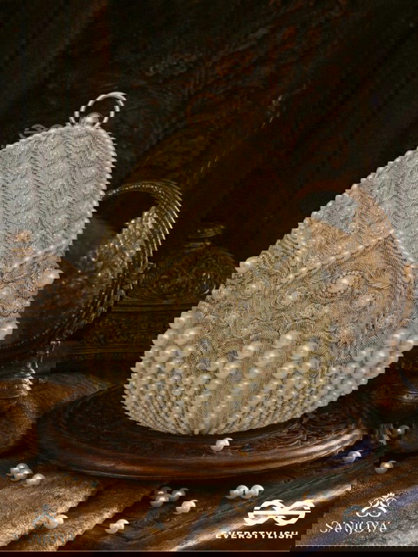 SAHIBA  – OVAL IVORY SILK CLUTCH WITH PEARL EMBEDDING AND GOLDEN METAL FRAME