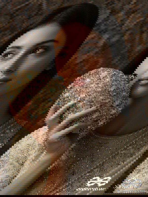 CHANDRAAYA – POLISHED OVAL GOLDEN BRONZE SILK CLUTCH WITH INTRICATE JEWEL STONE EMBELLISHMENT AND GOLDEN METAL FRAME