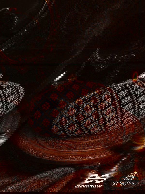 NAZRANA – CURVED MAROON SHADE TEXTILE CLUTCH WITH ORNAMENTED GRID EMBELLISHMENT AND GOLDEN METAL FRAME