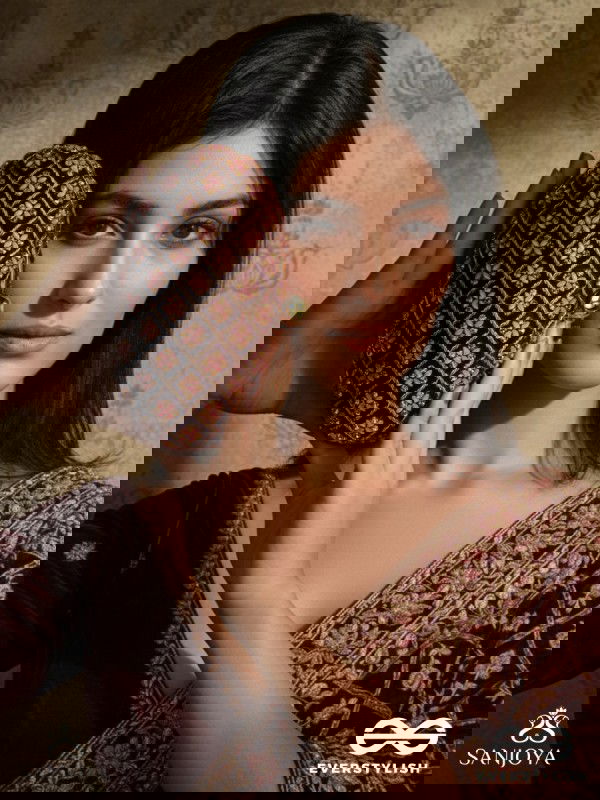 NAZRANA – CURVED MAROON SHADE TEXTILE CLUTCH WITH ORNAMENTED GRID EMBELLISHMENT AND GOLDEN METAL FRAME