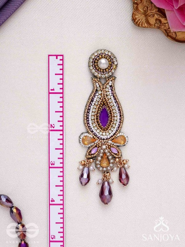 Divyaśhobhanā-Divine Splendour-Lotus-inspired embroidered design, adorned with purple and golden gem-studded motifs, Pearl and Beads.