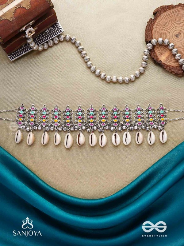 SHANKHAMALA-CONCH GARLAND- OXIDIZED NECKPIECE FEATURING PASTEL-COLOURED METALWORK, EMBELLISHED WITH DANGLING COWRIE SHELLS AND GHUNGROO'S