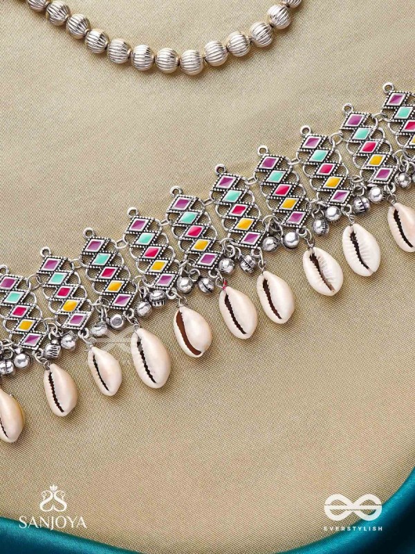 SHANKHAMALA-CONCH GARLAND- OXIDIZED NECKPIECE FEATURING PASTEL-COLOURED METALWORK, EMBELLISHED WITH DANGLING COWRIE SHELLS AND GHUNGROO'S