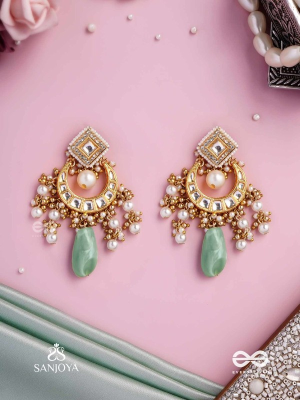 PURNIMA PHOOL – FULL MOON FLOWER AN EXQUISITE KUNDAN EARRING FEATURING GOLDEN DESIGNS, PEARL CLUSTERS, AND A GREEN GEMSTONE DROP, SYMBOLIZING ELEGANCE
