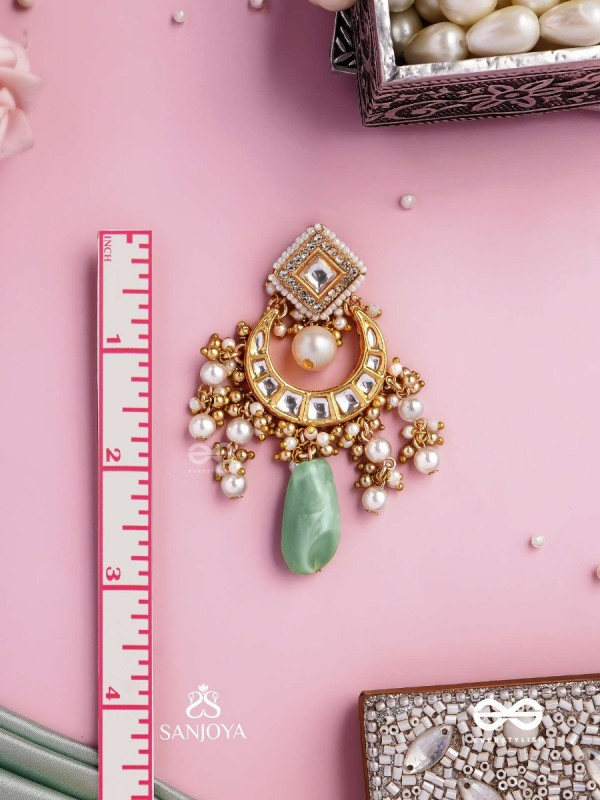 PURNIMA PHOOL – FULL MOON FLOWER AN EXQUISITE KUNDAN EARRING FEATURING GOLDEN DESIGNS, PEARL CLUSTERS, AND A GREEN GEMSTONE DROP, SYMBOLIZING ELEGANCE