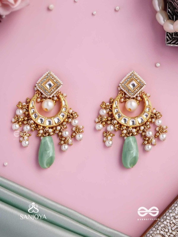 PURNIMA PHOOL – FULL MOON FLOWER AN EXQUISITE KUNDAN EARRING FEATURING GOLDEN DESIGNS, PEARL CLUSTERS, AND A GREEN GEMSTONE DROP, SYMBOLIZING ELEGANCE