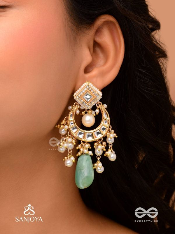 PURNIMA PHOOL – FULL MOON FLOWER AN EXQUISITE KUNDAN EARRING FEATURING GOLDEN DESIGNS, PEARL CLUSTERS, AND A GREEN GEMSTONE DROP, SYMBOLIZING ELEGANCE