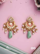 PURNIMA PHOOL – FULL MOON FLOWER AN EXQUISITE KUNDAN EARRING FEATURING GOLDEN DESIGNS, PEARL CLUSTERS, AND A GREEN GEMSTONE DROP, SYMBOLIZING ELEGANCE