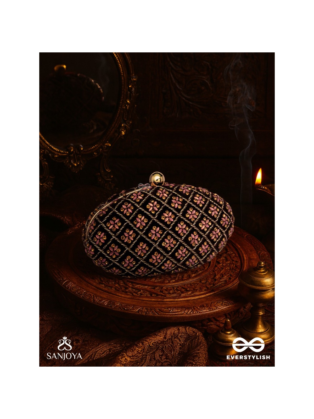 NAZRANA – CURVED MAROON SHADE TEXTILE CLUTCH WITH ORNAMENTED GRID EMBELLISHMENT AND GOLDEN METAL FRAME