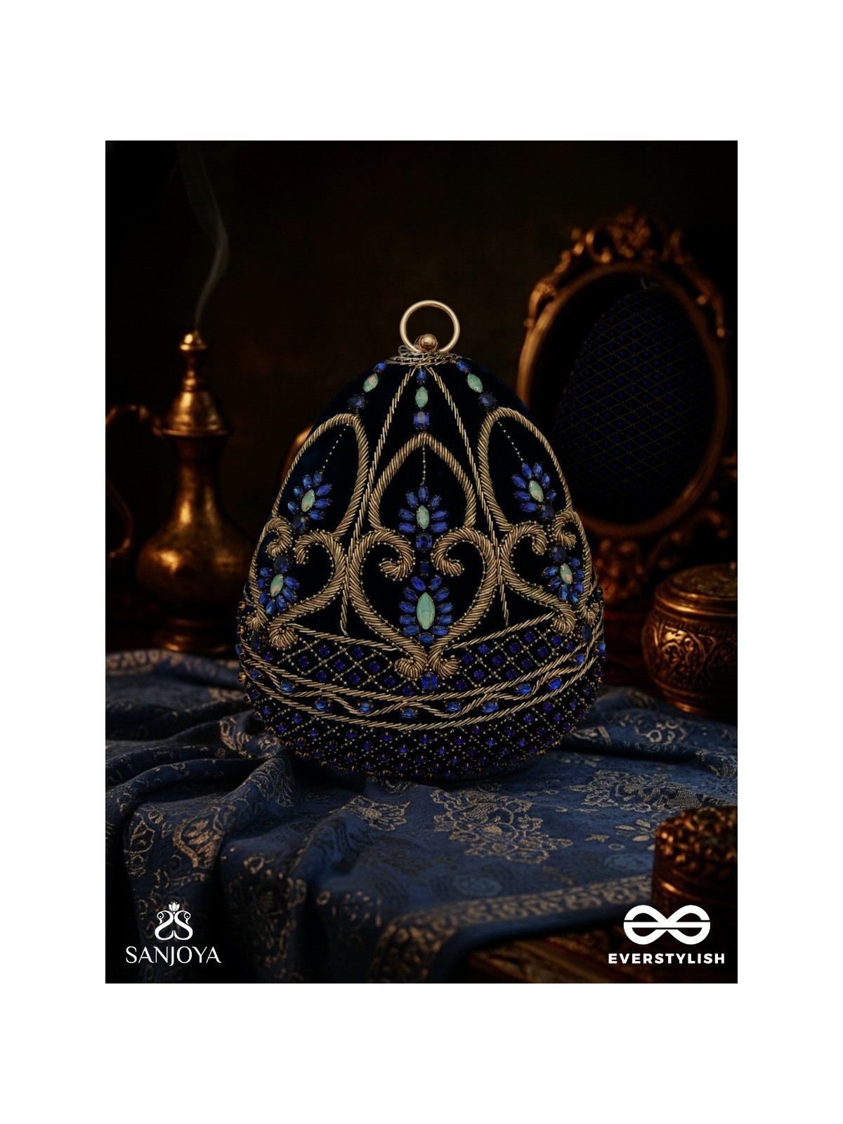 SITARAA – POLISHED OVAL ROYAL BLUE VELVET CLUTCH WITH STONE-ACCENTED HANDWORK AND GOLDEN METAL FRAME