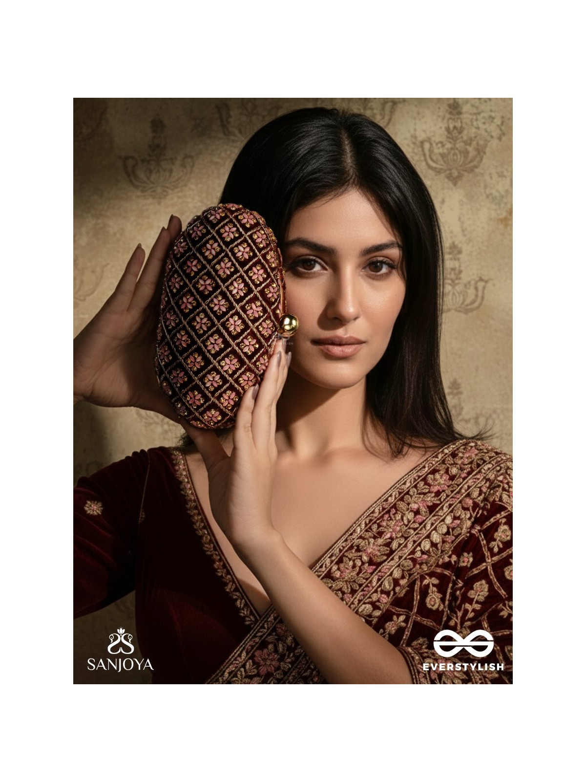 NAZRANA – CURVED MAROON SHADE TEXTILE CLUTCH WITH ORNAMENTED GRID EMBELLISHMENT AND GOLDEN METAL FRAME