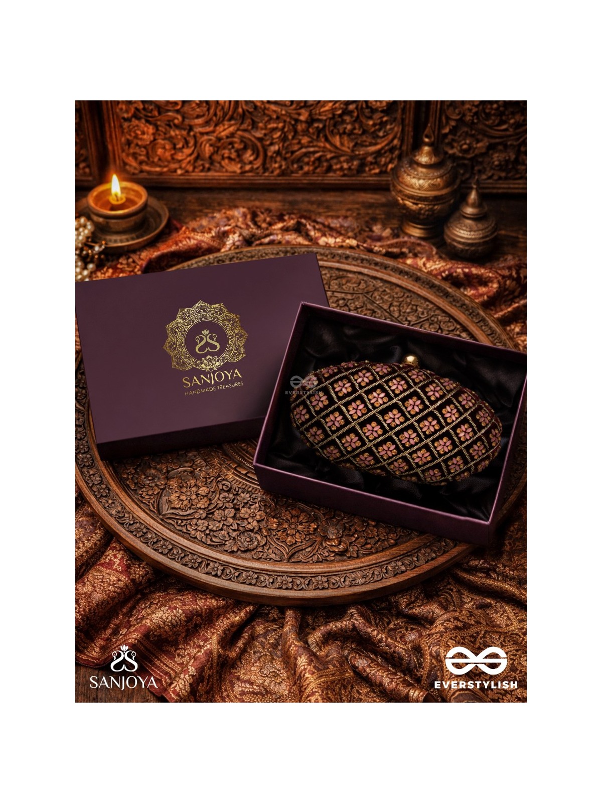 NAZRANA – CURVED MAROON SHADE TEXTILE CLUTCH WITH ORNAMENTED GRID EMBELLISHMENT AND GOLDEN METAL FRAME