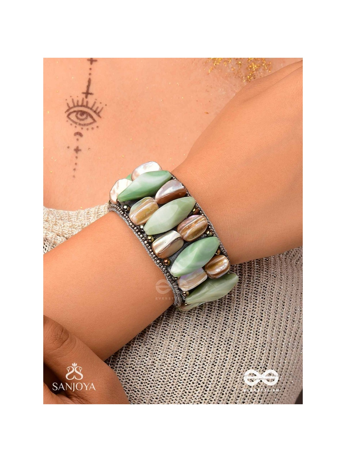 Shuktimālā- Shell band-Expandable bracelet crafted from shell beads, combining turquoise and beige-brown tones with a brassy finish.
