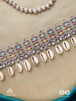 SHANKHAMALA-CONCH GARLAND- OXIDIZED NECKPIECE FEATURING PASTEL-COLOURED METALWORK, EMBELLISHED WITH DANGLING COWRIE SHELLS AND GHUNGROO'S